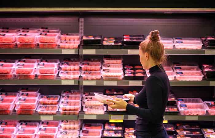 Woman shopping at the fresh meat section of the supermarket