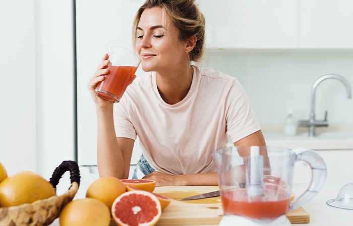 Woman drinking grapefruit juice