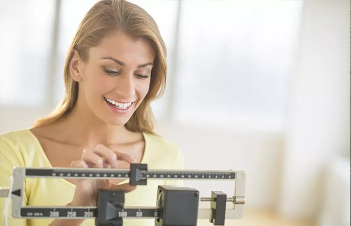 Woman checking her weight while following the vertical diet