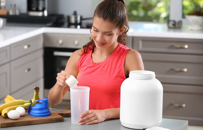 Woman on the bodybuilding diet adding protein supplement to her shake