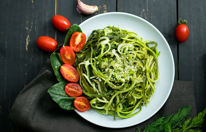 Zucchini noodles in pesto sauce with spinach and cherry tomatoes