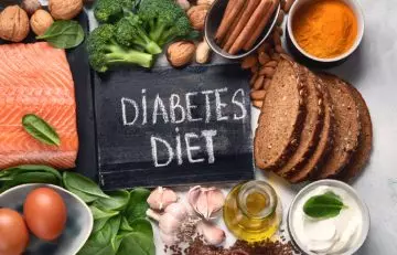 Healthy foods arranged around a diabetes diet board