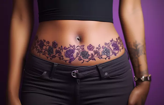 A black and purple rose tattoo belt on the lower belly