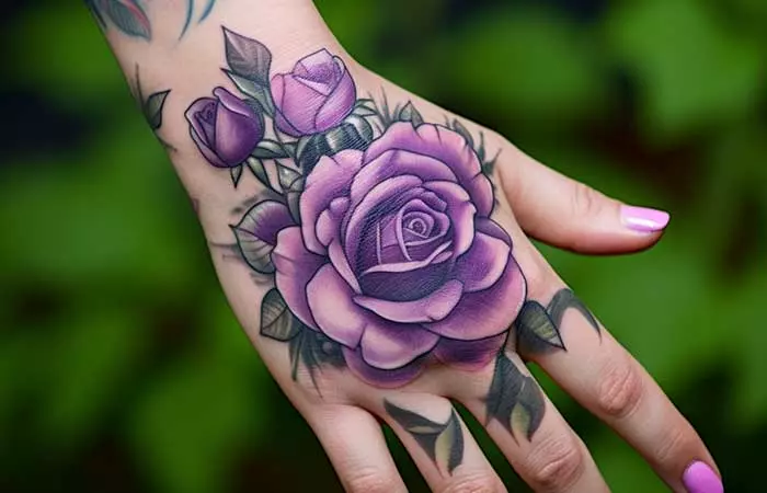 A bunch of purple roses tattooed on the back of the hand
