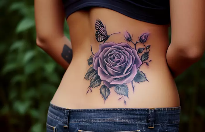 A gothic purple rose tattoo with a butterfly on the lower back