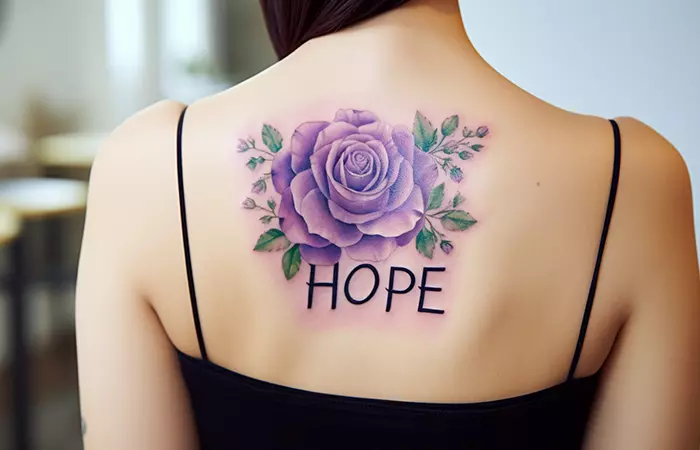 A name and purple rose tattoo on the back