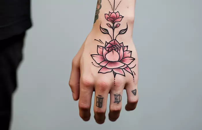 A rose and lotus tattoo on the back of the hand