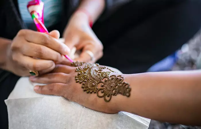 A woman applying henna tattoo
