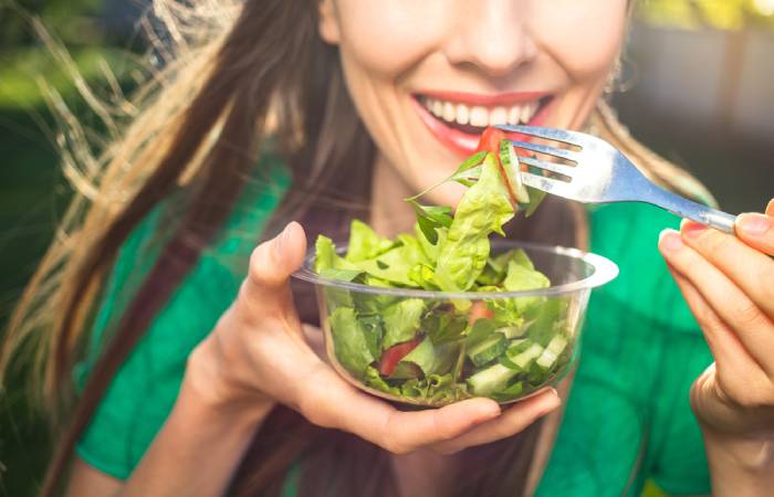 A woman eating healthy greens