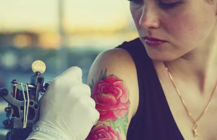 A woman getting a tattoo with vibrant colored ink pigments