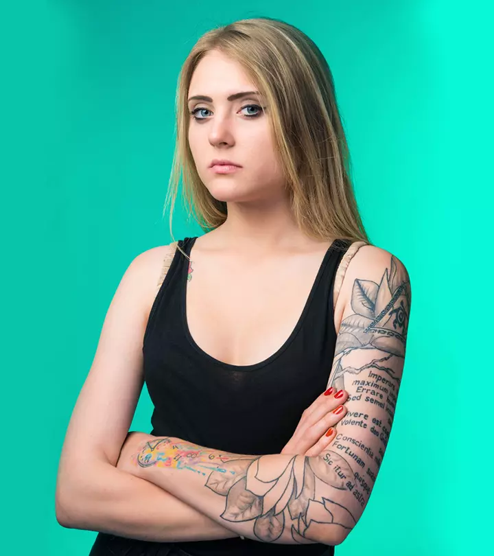 A woman with arm tattoos experiencing tattoo regret