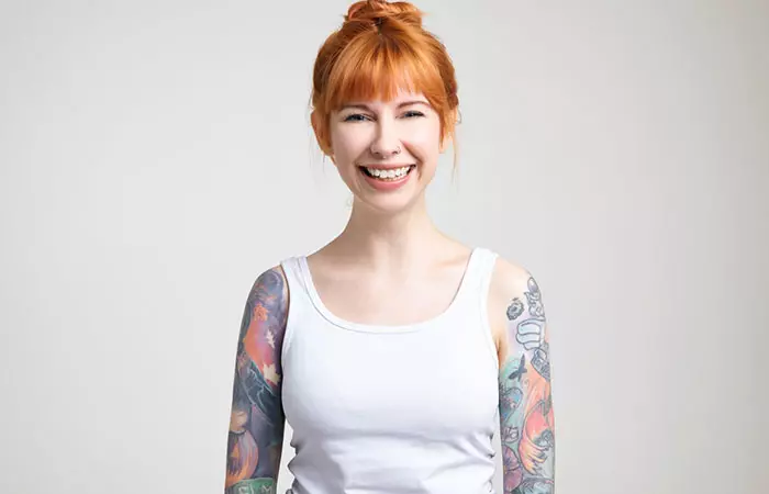 A woman with both her arms covered in colorful sleeve tattoos