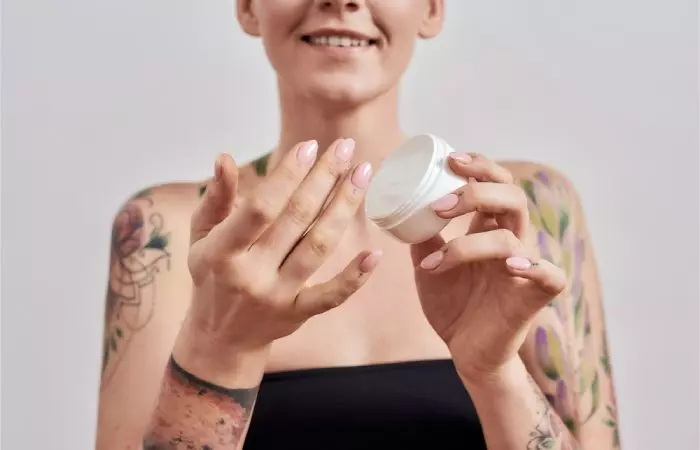 A woman with tattoos using Eucerin