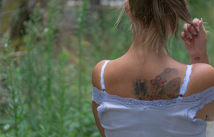 A young woman with a fading tattoo blowout on her back.