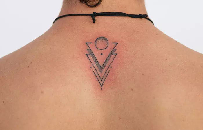 A fresh tattoo with geometric motifs on the back of an individual indicating slight skin irritation