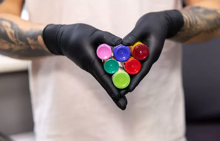 A person holding tattoo colors