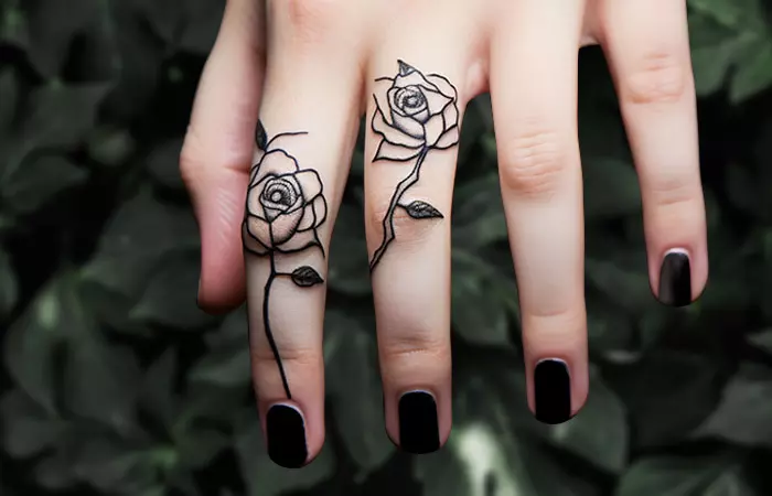 Small black roses tattooed on the fingers