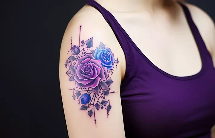 Geometric blue and purple rose tattoo on the upper arm