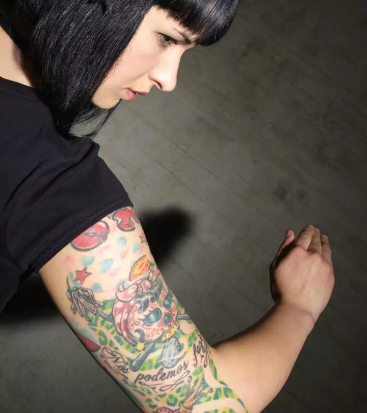 A woman with upper arm and elbow tattoos