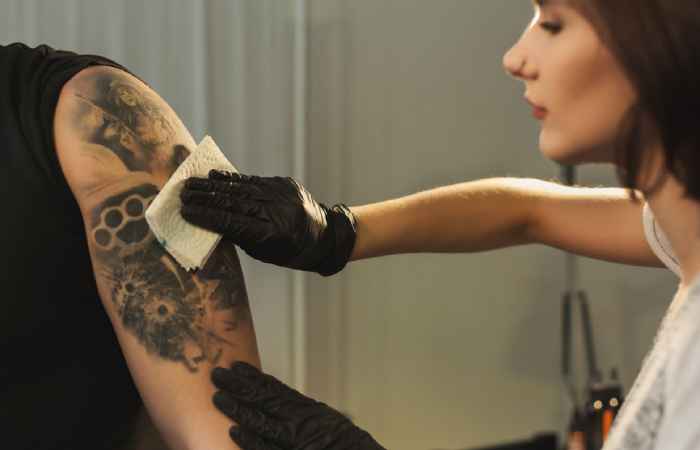 tattoo artist wiping the tattoo area