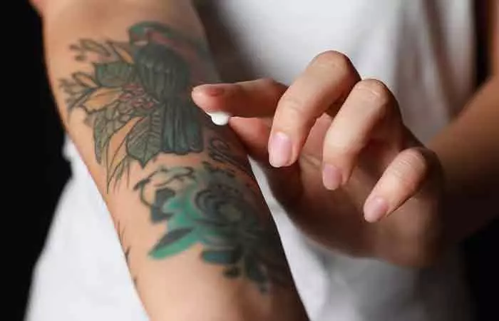 Woman applying CeraVe to tattooed skin 