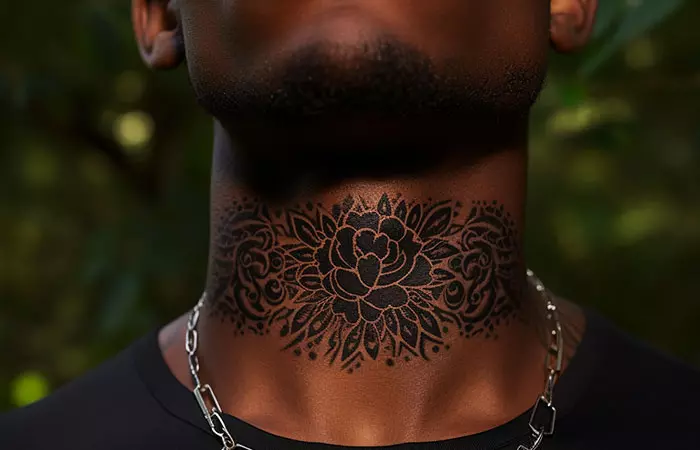 An ornamental multiflora rose tattoo across the front of a man’s neck