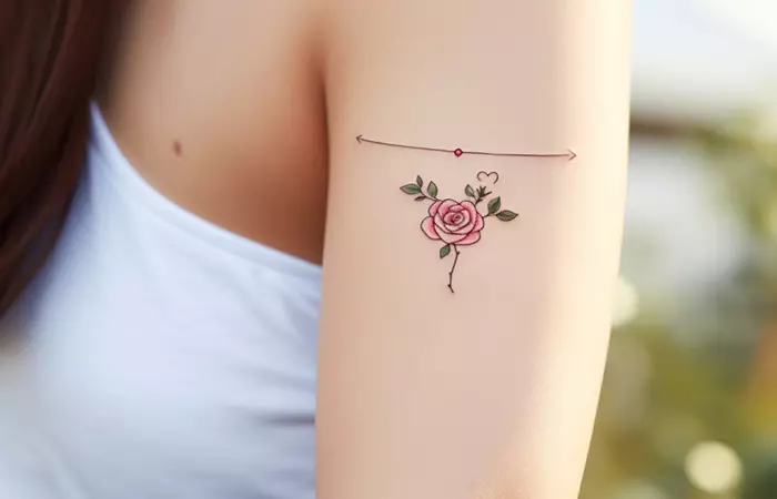 A micro red rose tattoo with opposite rays