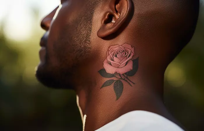 A soft pink rose neck tattoo on a deep skin tone