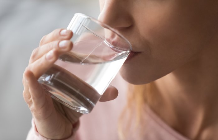 A woman drinking water to stay hydrated