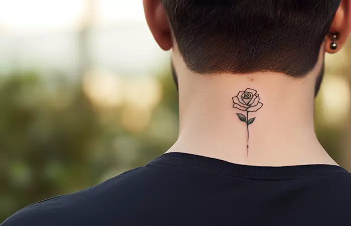 A small minimal outlined rose neck tattoo at the nape