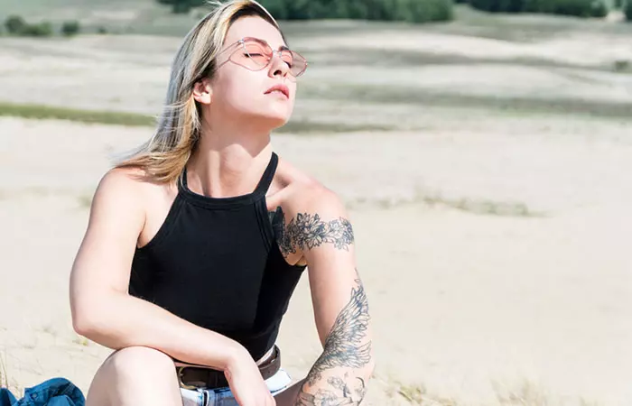 A tattooed woman under the sunlight