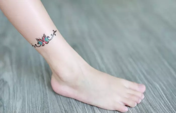 Tattoo around the ankle with a butterfly motif
