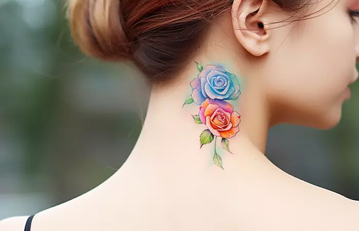 A watercolor rainbow rose neck tattoo behind the ear