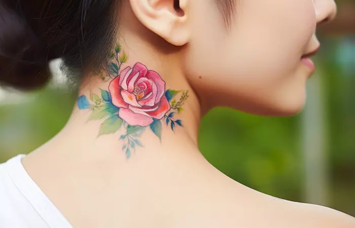 A graphic watercolor rose neck tattoo under the ear