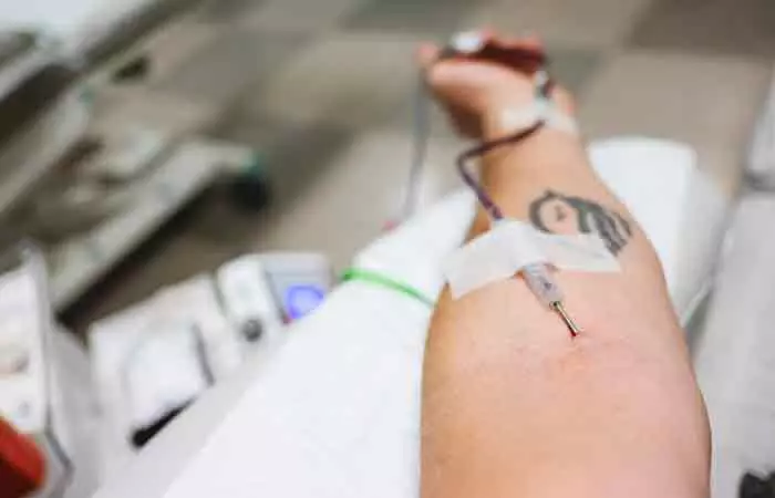 A close-up of an individual’s arm during an ongoing blood transfusion