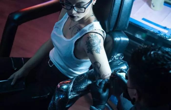 A woman getting an elbow tattoo
