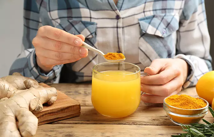 Woman adding turmeric to her drink