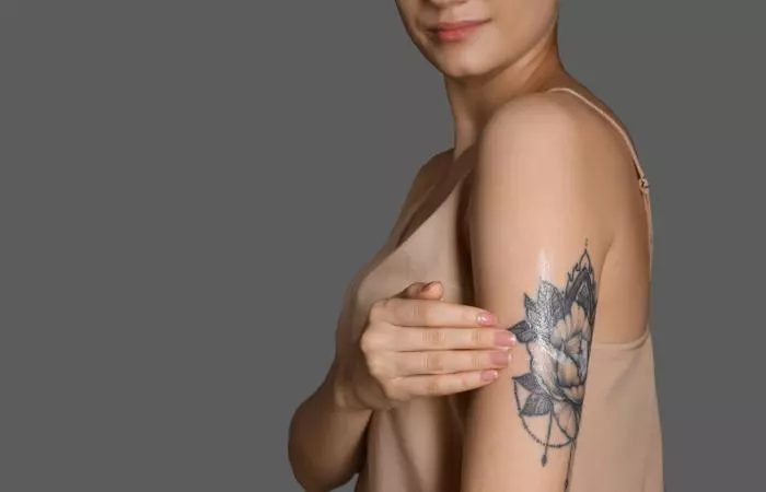 Woman applying tattoo aftercare ointment on her tattoo