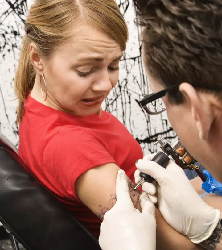 Woman getting tattooed on her sensitive skin