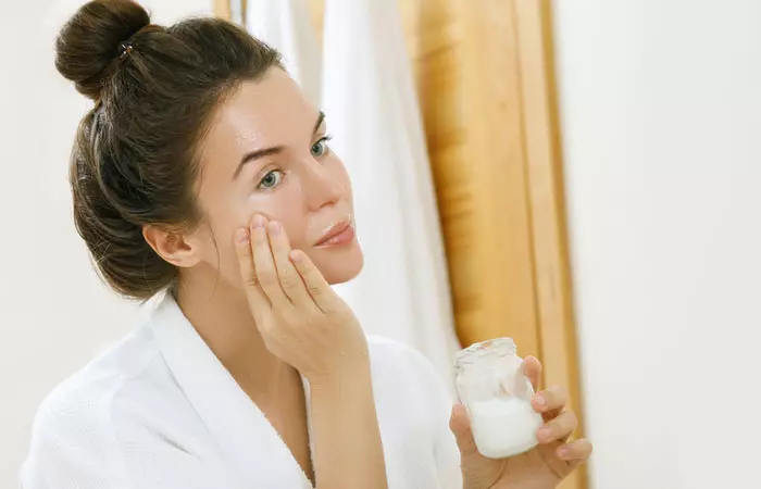 Woman using coconut oil as moisturizer