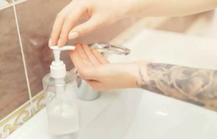 Woman washing her tattoo with antibacterial soap.