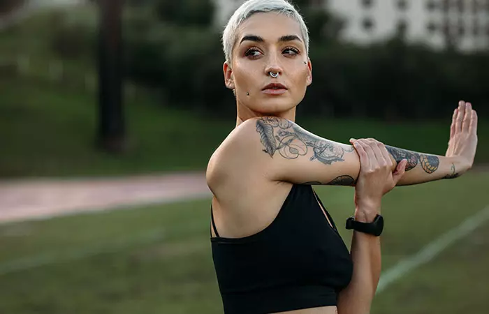 Woman with tattoos on her arm exercising