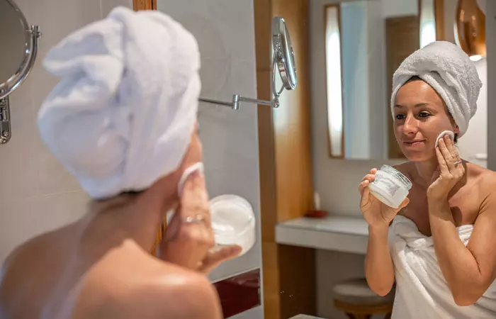 a woman removing makeup with coconut oil