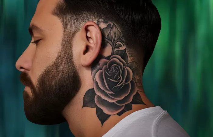 A black and gray ink-washed rose neck tattoo behind the ear