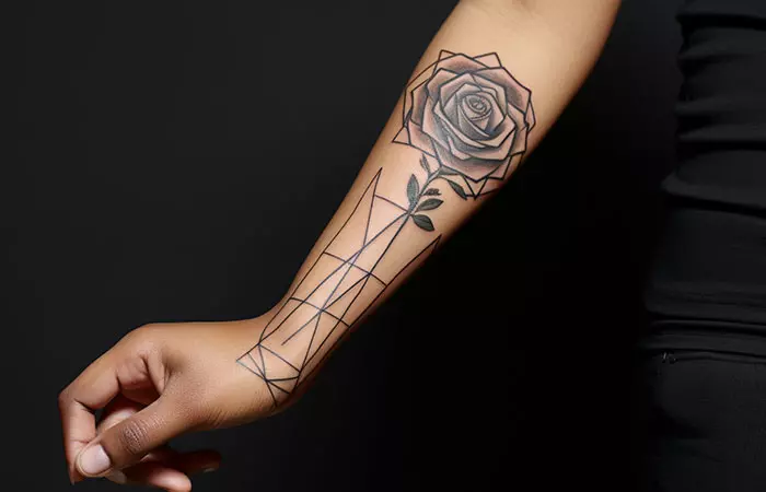 A minimal geometric black rose tattoo design on the forearm