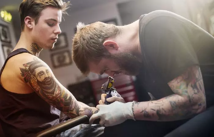 A man getting a tattoo sleeve done by a professional tattoo artist