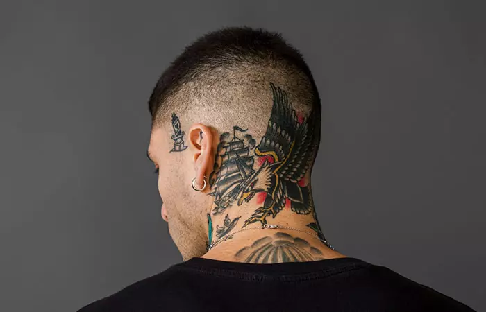 A man with an eagle tattoo on his neck