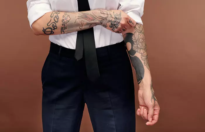 A mid shot of a tattooed lawyer in formalwear