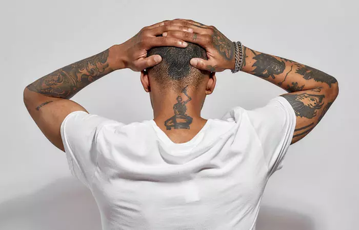 A person with back of the neck and arm tattoos