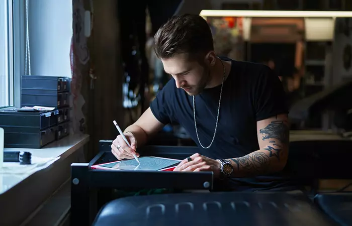 A tattoo artist sketching out a design